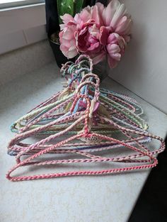 pink tulips in a glass vase on a counter with rope wrapped around them