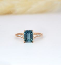 an emerald colored ring with diamonds on it