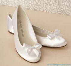 a pair of white shoes with bows on them