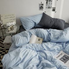 an unmade bed with blue and white sheets