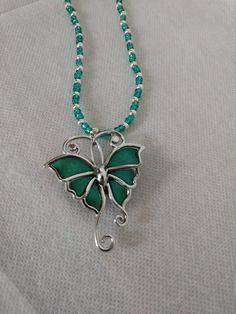 "This is a beautiful way to express your love for butterflies or give it to someone that loves butterflies. Big green and silver butterfly pendant hangs from a handmade green and silver seed bead necklace. Great to wear as casual or dressy.  Measurements: Beads seed bead Necklace 18\" Pendant 2 1/2\" X 2 1/2\"" Elegant Green Butterfly Necklace, Green Butterfly Charm Pendant Necklace, Handmade Green Butterfly Necklace, Silver Beaded Butterfly Necklace, Green Pendant Necklace With Silver Beads, Green Sterling Silver Beaded Necklace With Silver Beads, Green Bohemian Butterfly Jewelry, Bohemian Green Butterfly Jewelry, Green Butterfly Pendant Necklace