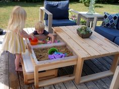 two children playing in a sandbox on a deck