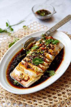 a white plate topped with fish covered in sauce