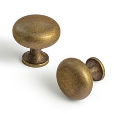 two brass colored knobs on white background