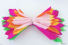 a colorful butterfly made out of paper on a white surface