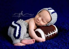 a baby wearing a football hat and diaper is laying on top of a blue blanket