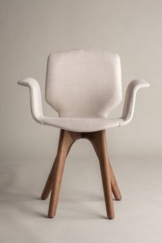 a white chair with wooden legs and an armrest that is shaped like a bird