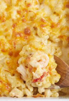 a wooden spoon in a casserole dish filled with macaroni and cheese