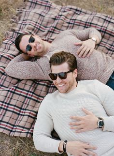 a man and woman laying on top of a blanket