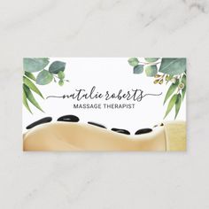 a massage business card with watercolor leaves and black stones on the back of it