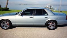 a silver car parked in front of a body of water