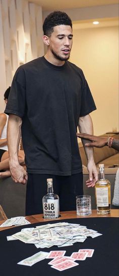 a man standing in front of a table with bottles on it