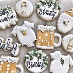 decorated baby shower cookies on a tray with white frosting and gold trimmings