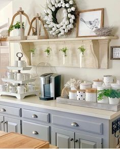 the kitchen counter is decorated with white pumpkins and greenery on it's shelves