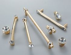 several different types of gold jewelry on a gray surface with diamond eyeshades and nose rings