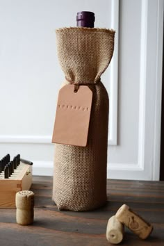 a wine bottle wrapped in burlap next to some corks