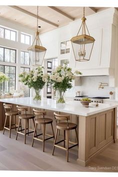 a large kitchen with an island and lots of stools