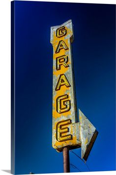 an old neon sign with the word garage painted on it's side against a blue sky