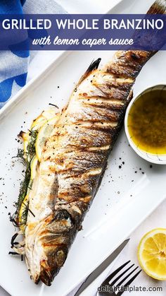 grilled whole branzotto with lemon caper sauce on a white platter