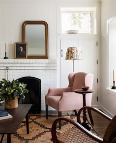 a living room filled with furniture and a fire place next to a mirror on the wall