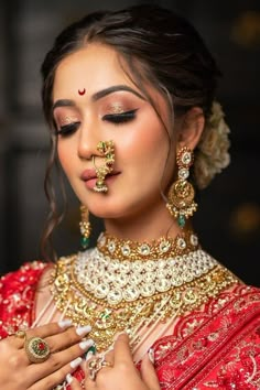 a woman in red and gold outfit with jewelry on her face, wearing an elaborate necklace