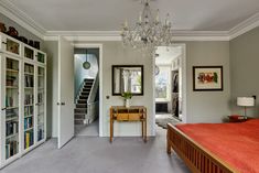 a bedroom with a bed, chandelier and bookshelves in the room