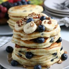 a stack of pancakes topped with bananas and blueberries