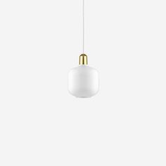 a white and gold pendant light hanging from a ceiling fixture in an empty room with no one around it