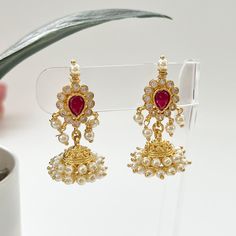 The perfect modern update to your traditional jewelry collection, these gold-plated jhumkas feature ruby and cubic zirconia accents with a classic design element.  Show off your style with these beauties! Length 1.1" | Width .75" Items are carefully packed and ready for gifting. All pictures are taken in natural light please allow for slight variations in color due to camera settings. Jewelry Care ✨Protect your jewelry in a closed box or pouch   ✨Wear jewelry after you have applied lotion or per South Indian Earrings, Temple Indian, Temple Jewelry, Traditional Earrings, Indian Earrings, Earrings Pearl, Jhumka Earrings, Temple Jewellery, Traditional Jewelry