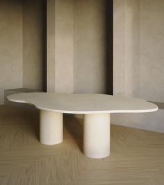 a white table sitting on top of a hard wood floor next to two tall walls