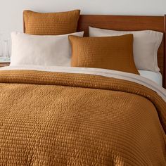 a bed with brown and white linens in a bedroom