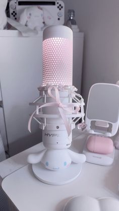 a pink and white lamp sitting on top of a table next to an open mirror