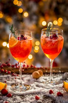 two glasses filled with wine and garnished with cranberries