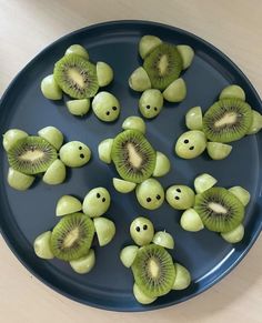 sliced kiwis arranged in the shape of faces on a blue plate