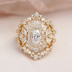 a diamond ring is sitting on top of a white cloth