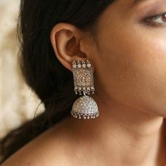 Silver oxidised earrings are an obsession for us and we fuel the obsession with a big bold version of the same recreated in these lovely earrings. Jhumkis remains an integral part of Indian dressing and will be adorned forever. This Antique Silver Jhumki Earrings will be a perfect accessory to complete your ethnic look this season. The beauty of this accessory lies in the intricate circular motifs. This pair of earrings will justify your white shirt and that Kurta and denim casual look. Silver Jhumkas For Navratri, Oxidized Finish Jhumkas For Gift, Gift Oxidized Finish Jhumkas, Bollywood Oxidized Finish Jhumkas For Wedding, Bollywood Style Oxidized Jhumkas For Festive Occasion, Traditional Sterling Silver Jhumkas, Silver Jhumkas For Navratri Party, Diwali Oxidized Finish Drop Jhumkas, Diwali Oxidized Drop Jhumkas