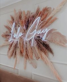 there is a sign that says love guy with feathers hanging on the wall behind it