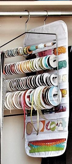 a rack that has many different types of ribbons hanging from it's sides and on the wall