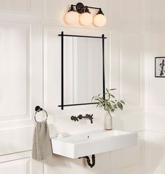 a bathroom with a sink, mirror and towel hanging on the wall next to it