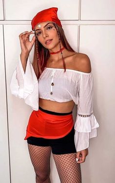 a woman in a red and white outfit posing for the camera with her hands on her face