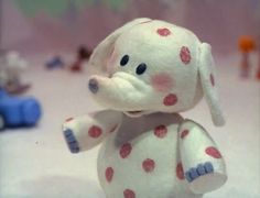 a small white stuffed animal with red polka dots