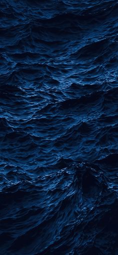 the water is very dark blue and it looks like waves