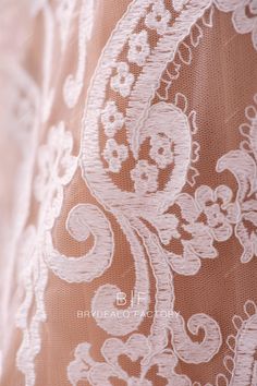 close up view of the back of a dress with white lace and flowers on it