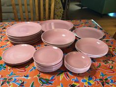 a table topped with lots of pink plates