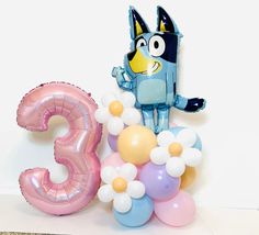 an animal balloon sitting on top of a table next to the numbers 3 and 3