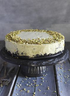 a cake sitting on top of a black plate with sprinkles around it