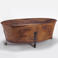 an old wooden table with iron legs and a round top that has been turned into a coffee table