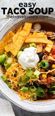 a bowl filled with taco soup, tortilla chips and sour cream on top