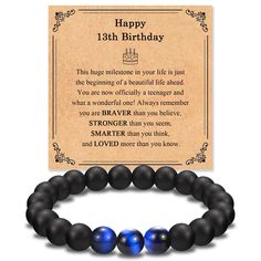 a bracelet with an inscription on it that says happy 13th birthday and two blue beads