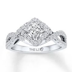 a white gold ring with diamonds on the band and a square shaped diamond in the center